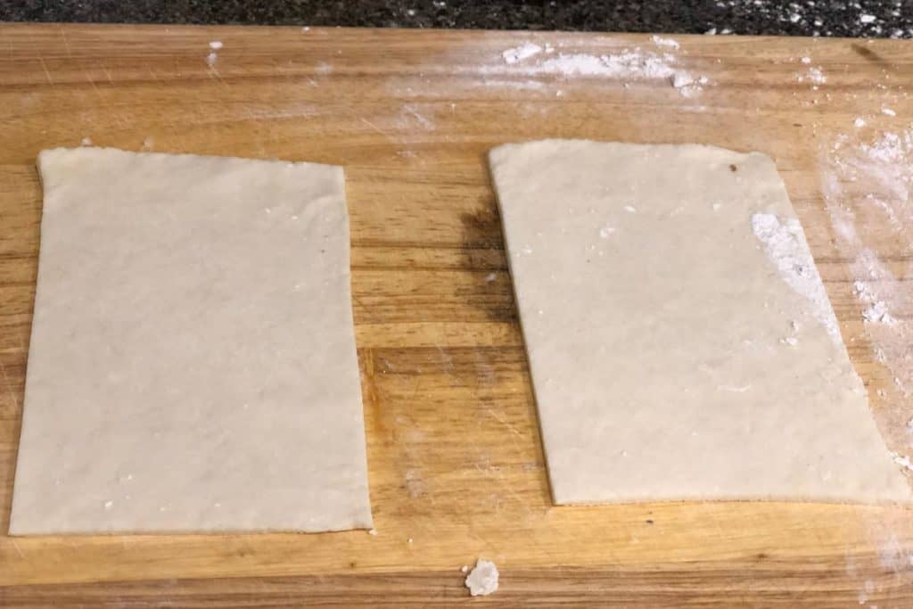 Two pieces of pop tart pie crust dough on a cutting board