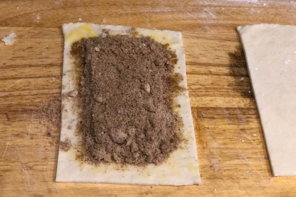 brown sugar cinnamon filling on top of the first piece of pastry crust dough