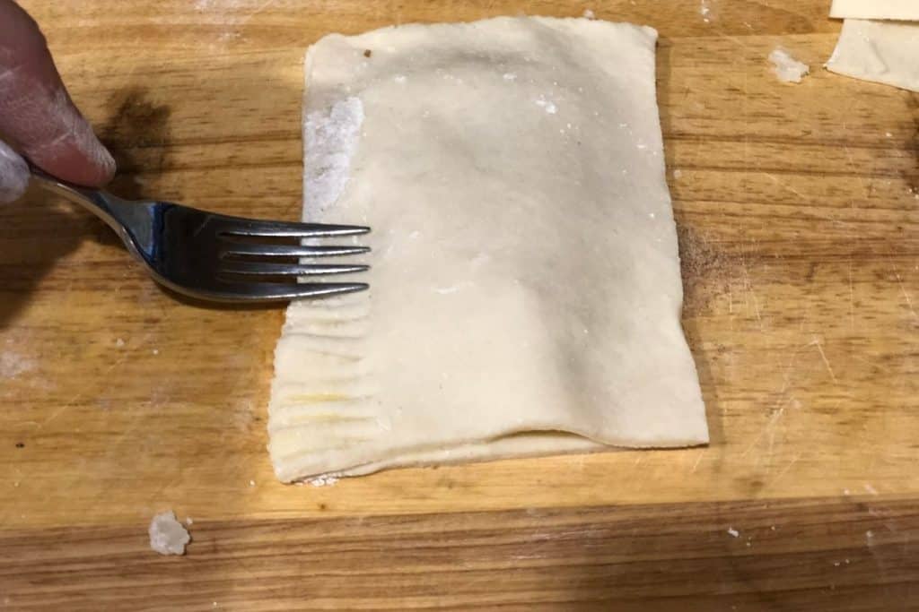 A fork crimping the edges of the pop tart closed