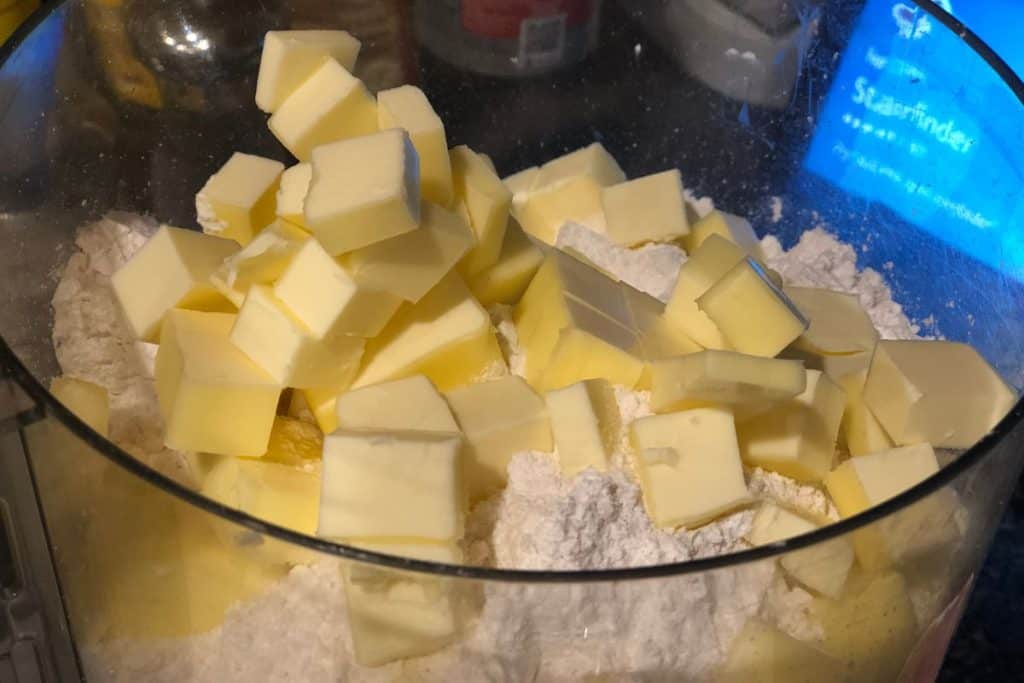 Cut up cubes of butter added to the flour and sugar in the food processor to make the pie pastry crust for homemade pop tarts