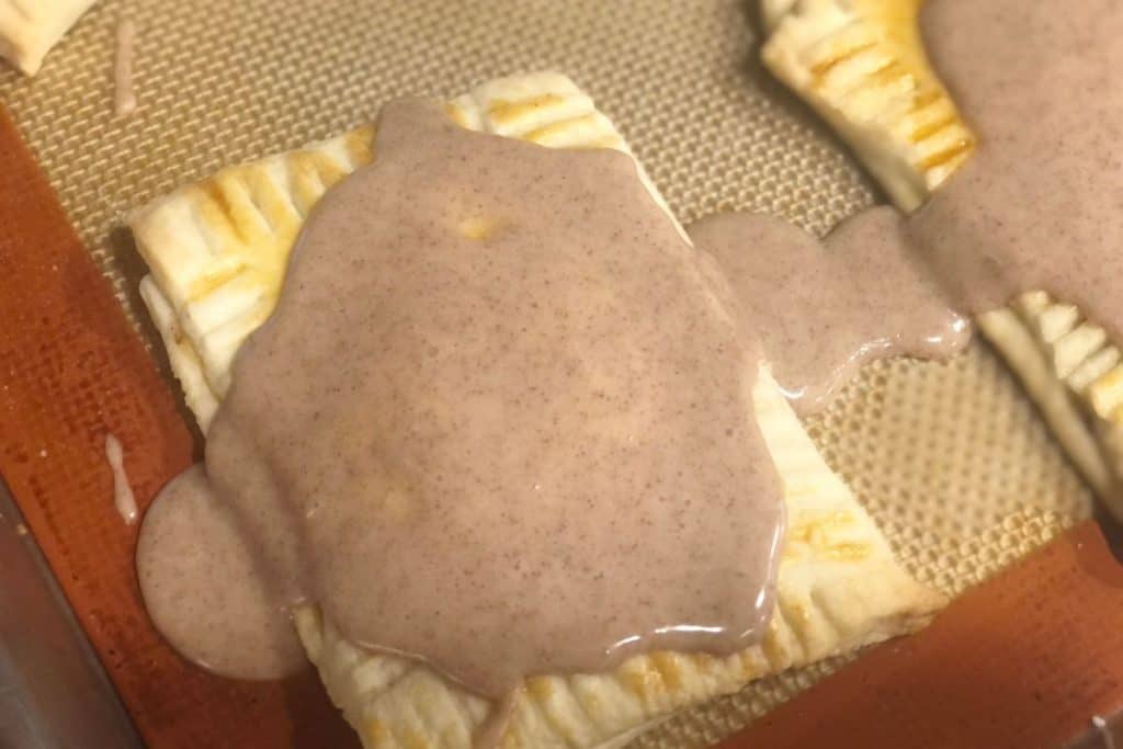 Homemade brown sugar cinnamon pop tarts with icing drizzling off the sides