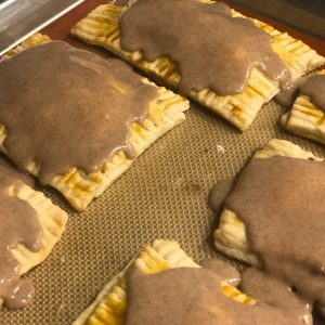 Brown sugar cinnamon pop tarts iced and cooling on the baking sheet