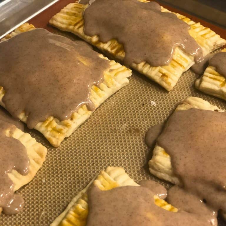 Brown sugar cinnamon pop tarts iced and cooling on the baking sheet