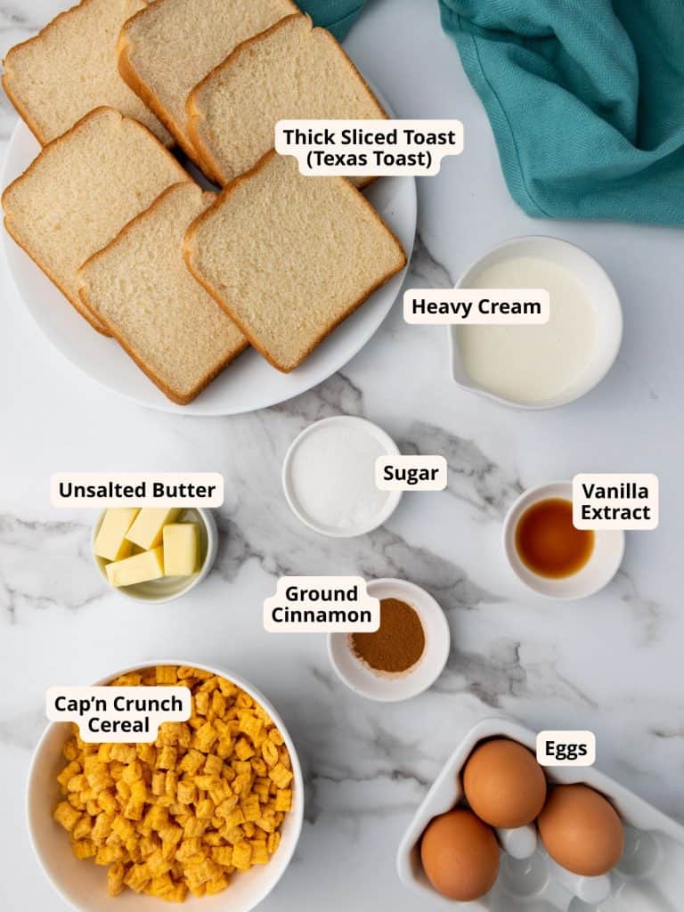 Ingredients for Captain Crunch French Toast including thick sliced bread, heavy cream, sugar, vanilla extract, butter, cinnamon, eggs and Cap'n Crunch cereal.