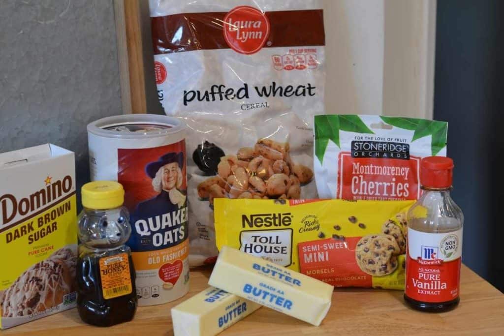 Ingredients for Cherry Chocolate Chip Granola Bars including puffed wheat, dried cherries, vanilla extract, chocolate chips, butter, oatmeal, honey and dark brown sugar.