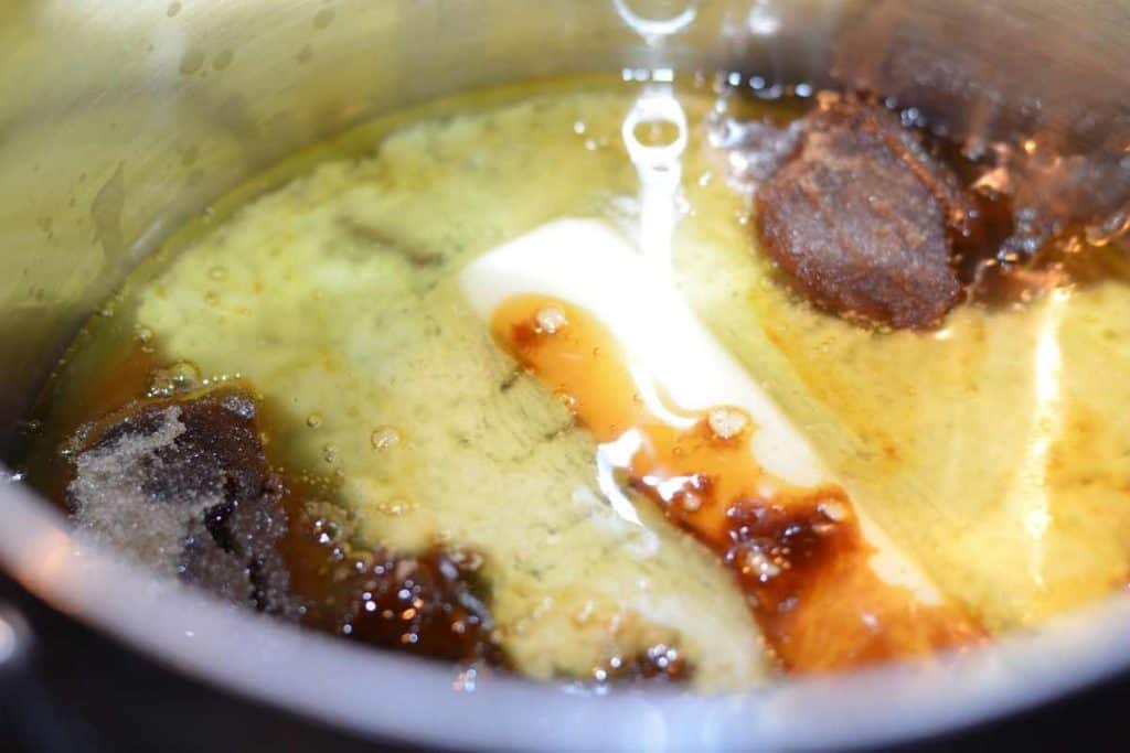 The brown sugar sauce ingredients in the sauce pan including honey, butter, vanilla and brown sugar.
