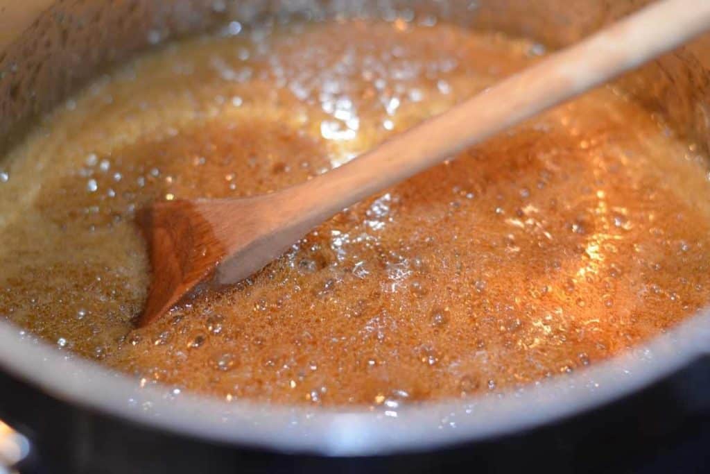 The brown sugar honey sauce that binds the granola bars together cooking on the stove and bubbling boiling.
