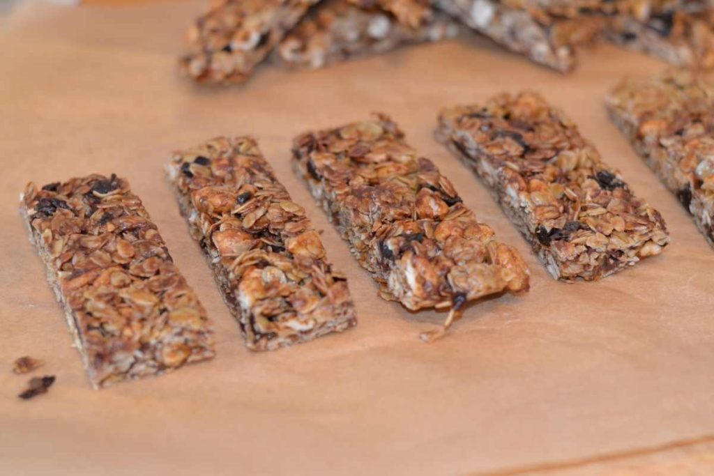 Cherry Chocolate Chip Granola Bars sliced up on parchment paper lined up in a row.