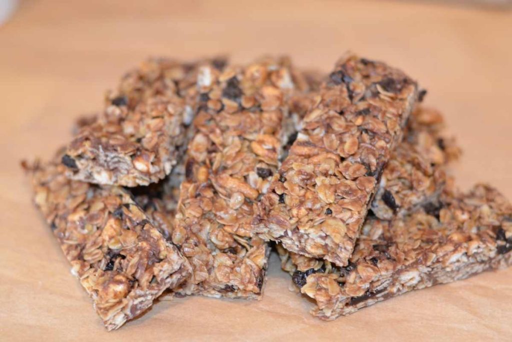 A pile of Cherry Chocolate Chip Granola Bars on brown parchment paper