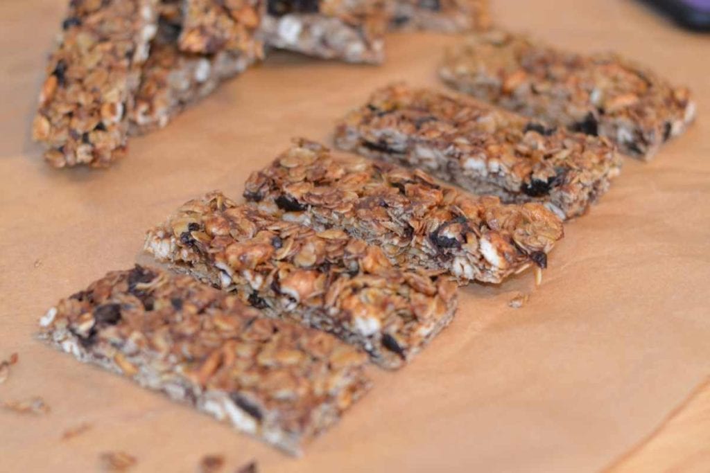 Cherry Chocolate Chip Granola Bars sliced up on parchment paper lined up in a row.