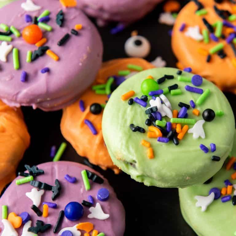 A close up of a stack of chocolate covered Halloween oreos