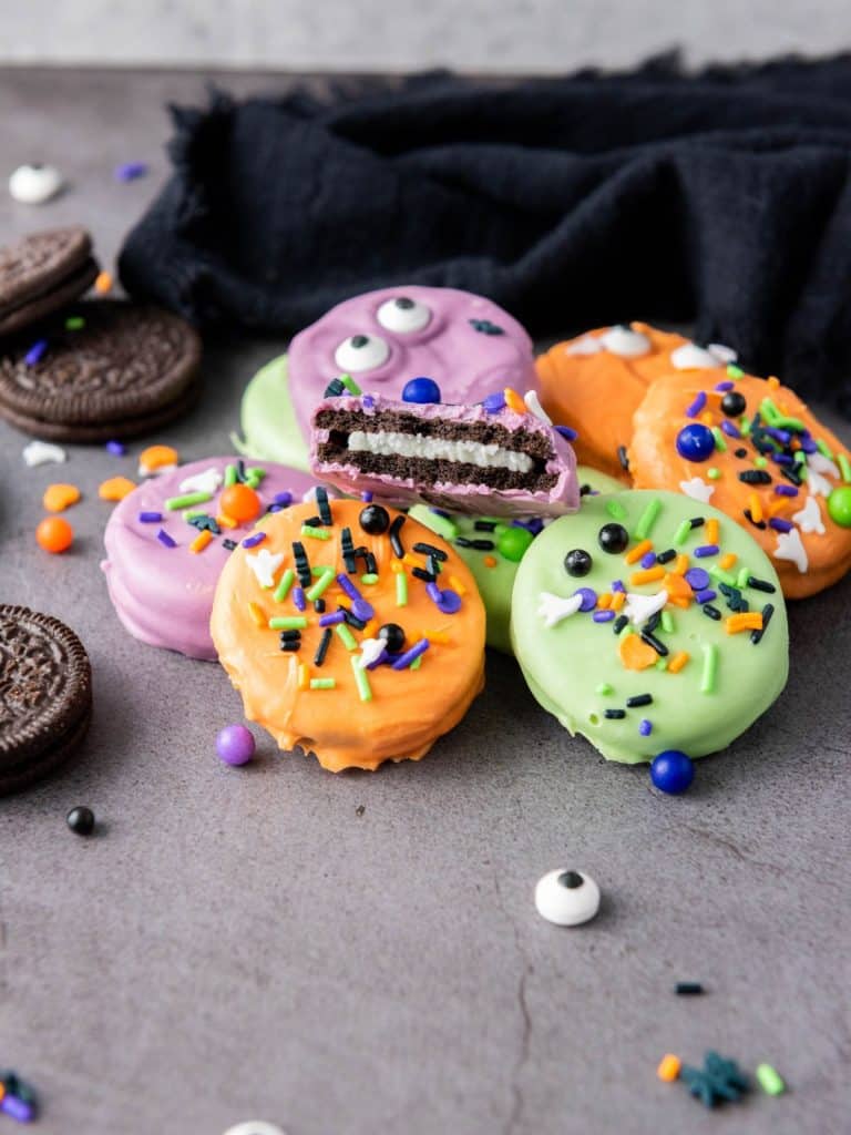 Bitten Halloween Oreo showing the cream filling inside colorful candy coating with sprinkles.